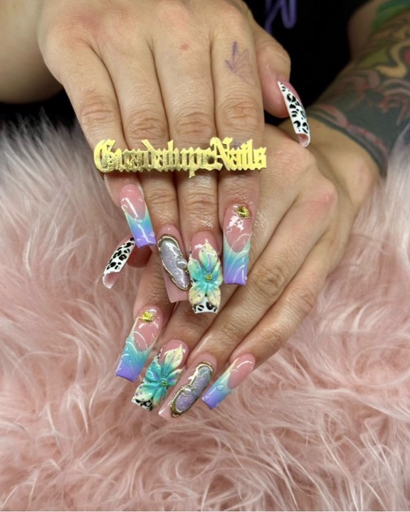 Pastel ombré coffin nails with painted blue flowers, cow print and gems