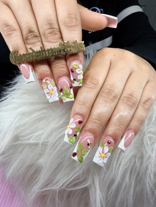 Long square white French tips with hand-painted daisies and leaves