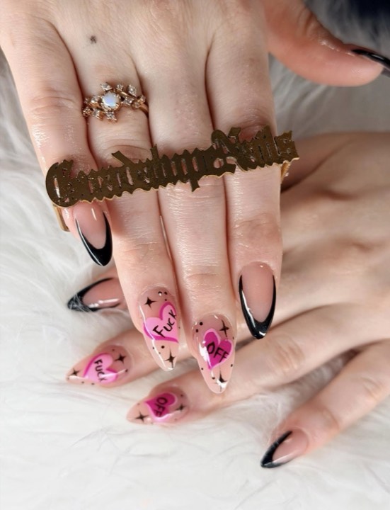 Almond nails with black French tips and pink heart accents