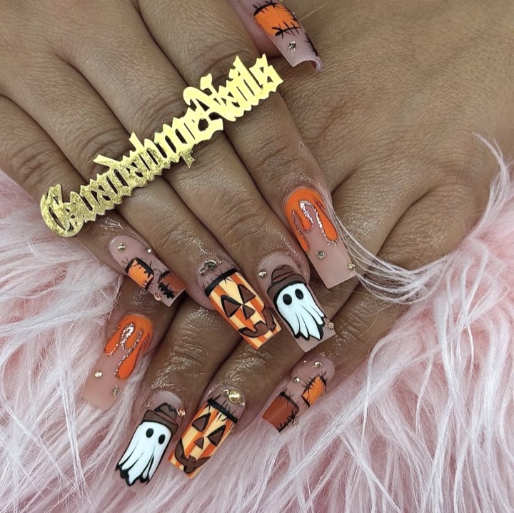 Long coffin nails with hand-painted Halloween pumpkins, ghosts and orange drip art