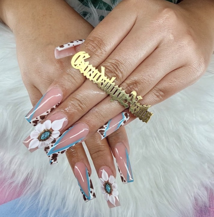 Coffin nails with blue and white French swirls, cow print and a white flower with a turquoise center