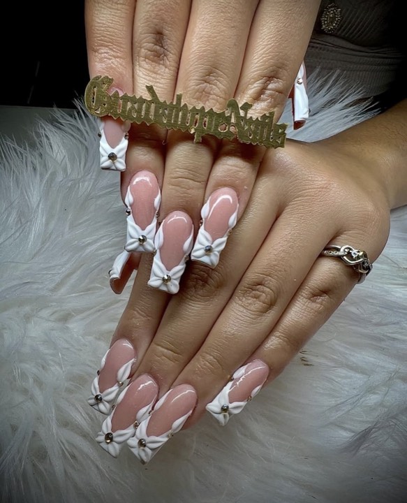 Long square nails with white V-shaped French tips and 3D white bows