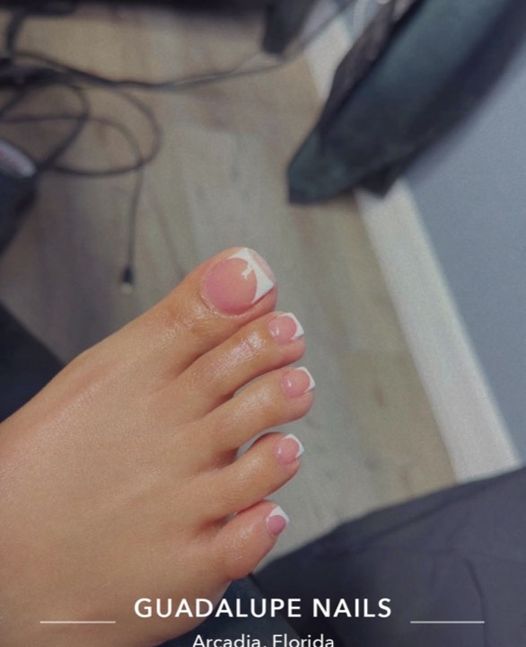 Toes with a classic pink and white French pedicure