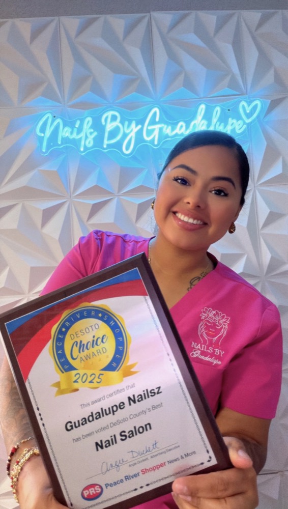 Guadalupe smiling in her studio, holding her 2025 DeSoto Choice Award plaque